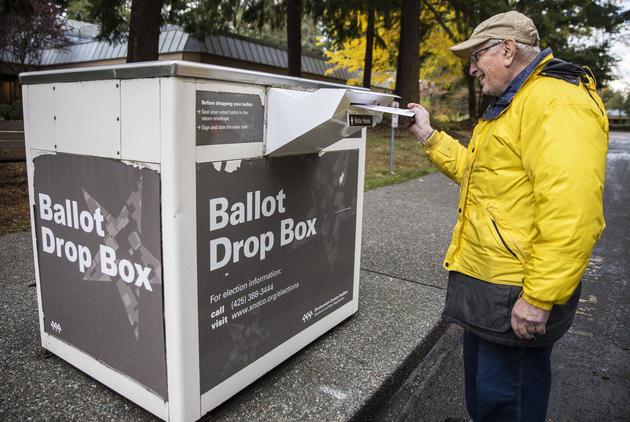 Dennis Michelson pushes his ballot into the drop box outside of Lynnwood City Hall on Nov. 2, 2022 in Lynnwood, Washington. (Olivia Vanni / The Herald)