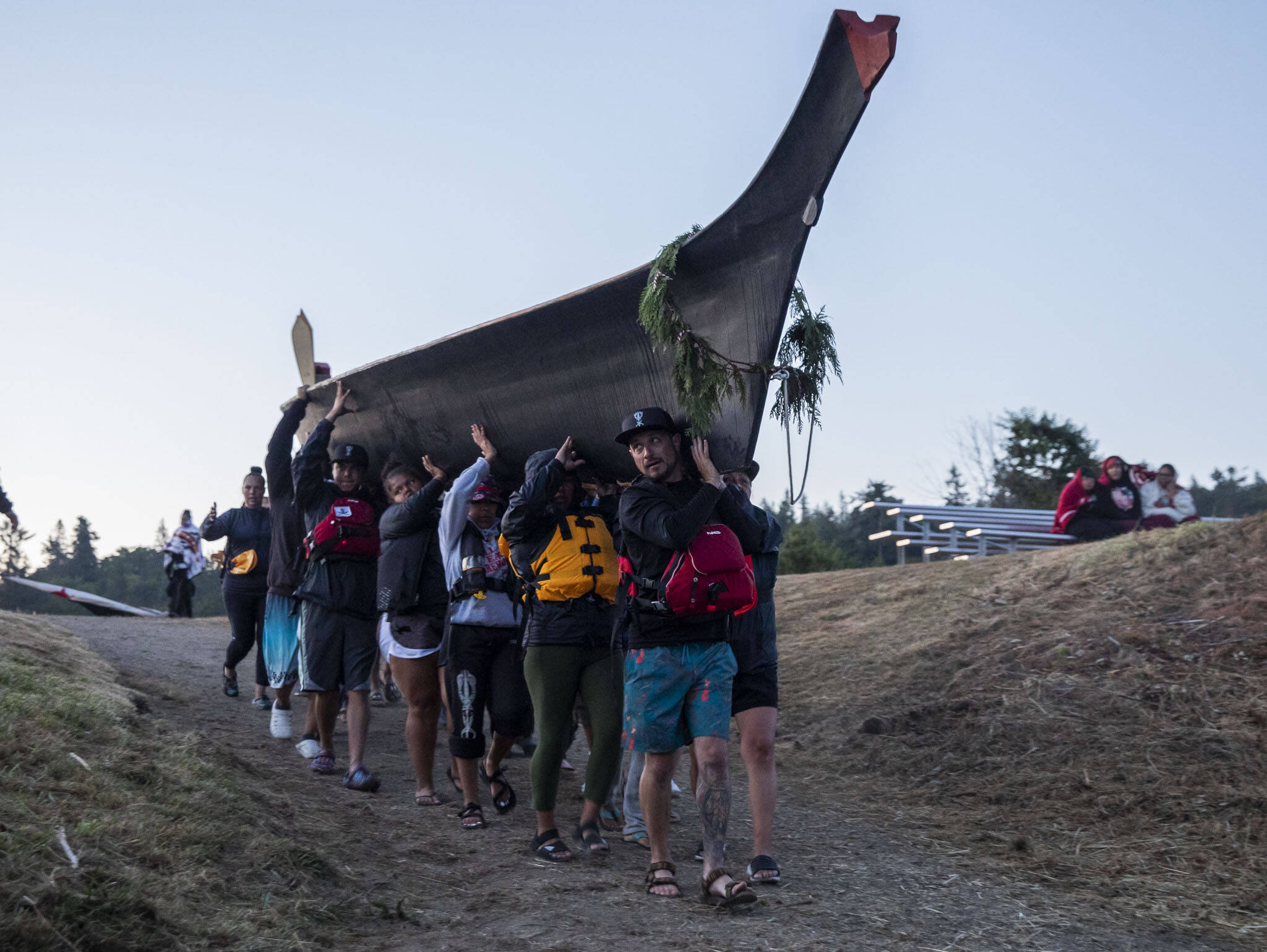 A large canoe is carried down to the water for departure on Friday, July 28, 2023 in Tulalip, Washington. (Olivia Vanni / The Herald)