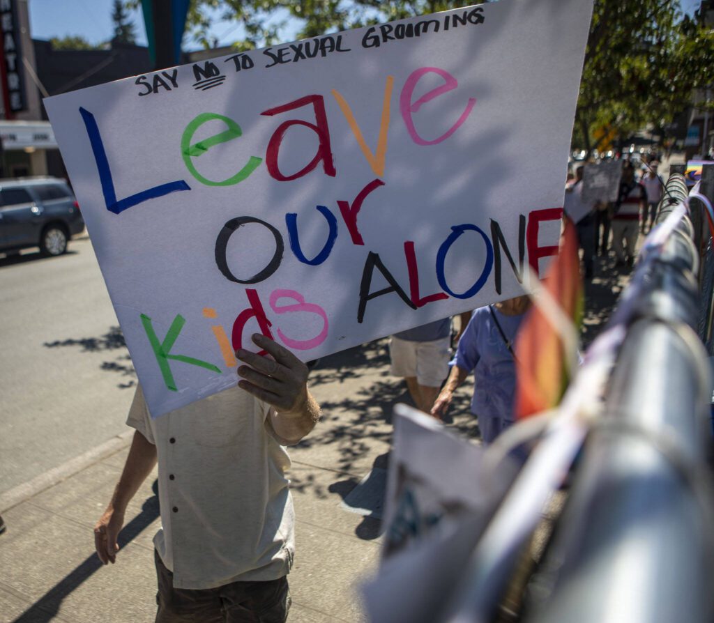 Protesters walk along the perimeter during the second annual Arlington Pride at Legion Memorial Park in Arlington, Washington on Saturday, July 22, 2023. (Annie Barker / The Herald)
