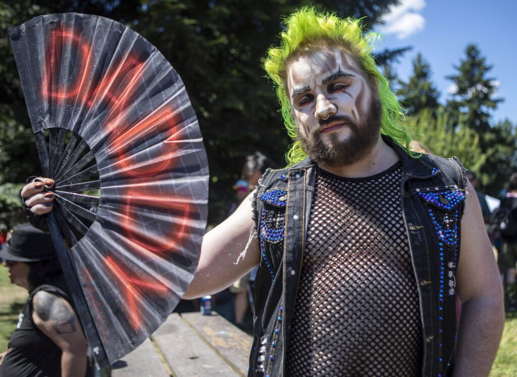 Prince Harming, 30, displays his fan for a portrait during the second annual Arlington Pride at Legion Memorial Park in Arlington, Washington on Saturday, July 22, 2023. (Annie Barker / The Herald)
