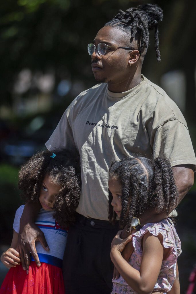 Left to right, Zoë Lindsey, 6, Nigel Lindsey, 31, and Aribella Lindsey, 7, listen during a NAACP Snohomish County press conference at Lynnwood City Hall in Lynnwood, Washington on Thursday, July 20, 2023. (Annie Barker / The Herald)
