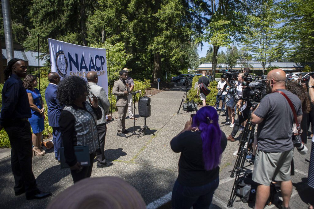Media and community members listen as Lynnwood City Councilmember Joshua Binda speaks during a NAACP Snohomish County press conference at Lynnwood City Hall in Lynnwood, Washington on Thursday, July 20, 2023. (Annie Barker / The Herald)
