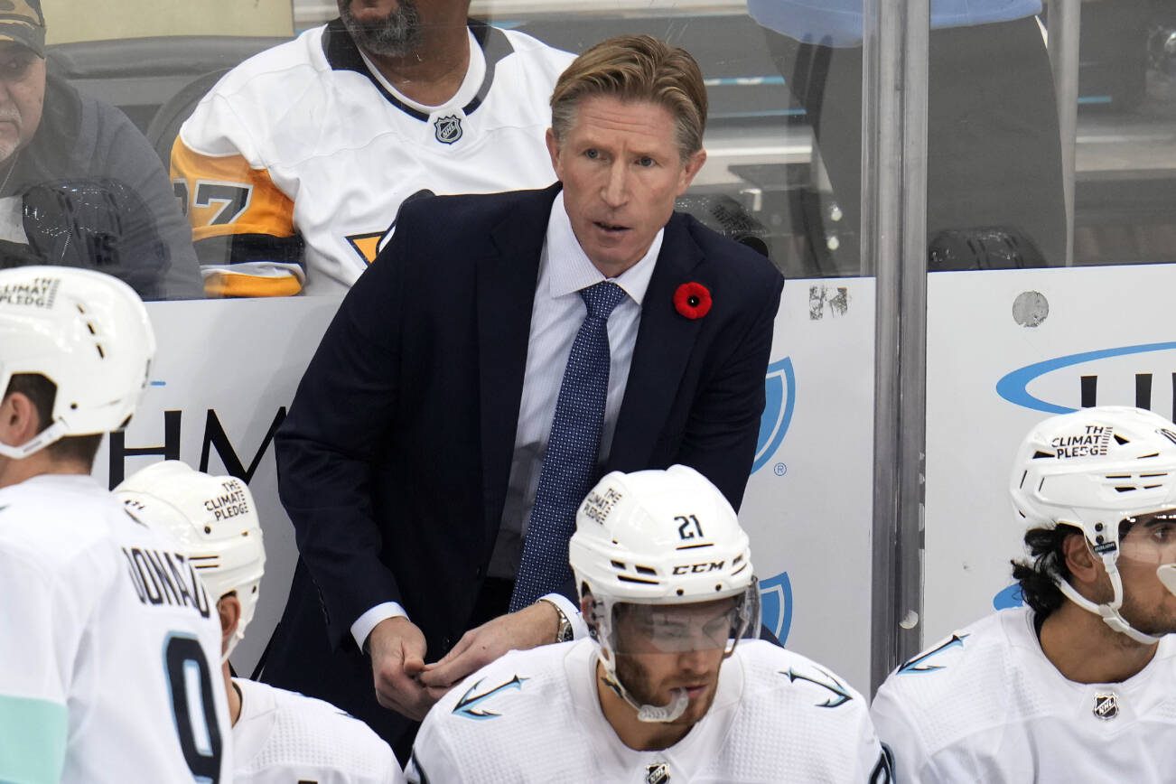 Seattle Kraken head coach Dave Hakstol stands behind his bench during the third period of an NHL hockey game against the Pittsburgh Penguins in Pittsburgh, Saturday, Nov. 5, 2022. The Kraken won 3-2. (AP Photo/Gene J. Puskar)