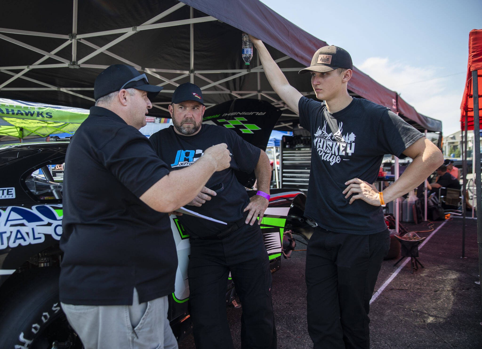 Kole Raz, right, talks with his pit crew during practice for Summer Showdown at Evergreen Speedway on Thursday in Monroe. (Olivia Vanni / The Herald)