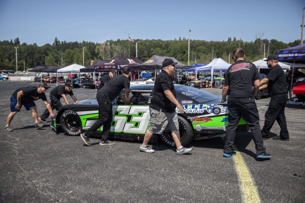 A tire is secured onto Preston Peltier’s car during practice for Summer Showdown at Evergreen Speedway on Thursday in Monroe. (Olivia Vanni / The Herald)
