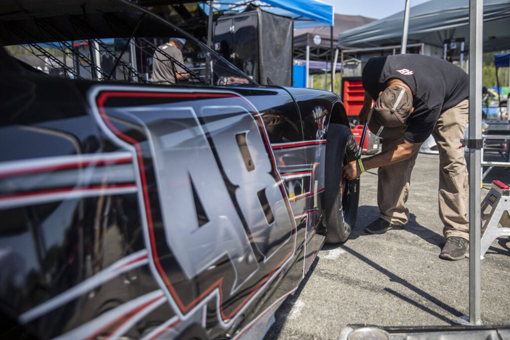 Kole Raz and his pit crew move his car in the pits during practice for Summer Showdown at Evergreen Speedway on Thursday in Monroe. (Olivia Vanni / The Herald)
