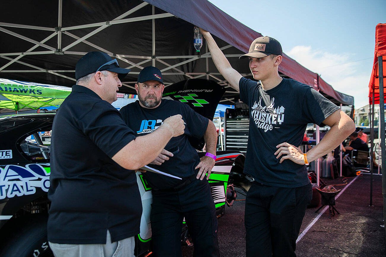 Kole Raz, right, talks with his pit crew during practice for Summer Showdown at Evergreen Speedway on Thursday, July 20, 2023 in Monroe, Washington. (Olivia Vanni / The Herald)
