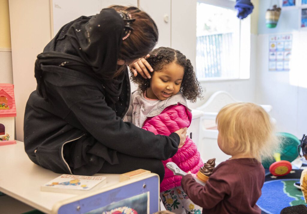 Katie, 3, gives a hug to one of her teachers at Tomorrow’s Hope Child Development Center on Wednesday, Nov. 23, 2022 in Everett, Washington. (Olivia Vanni / Herald file)
