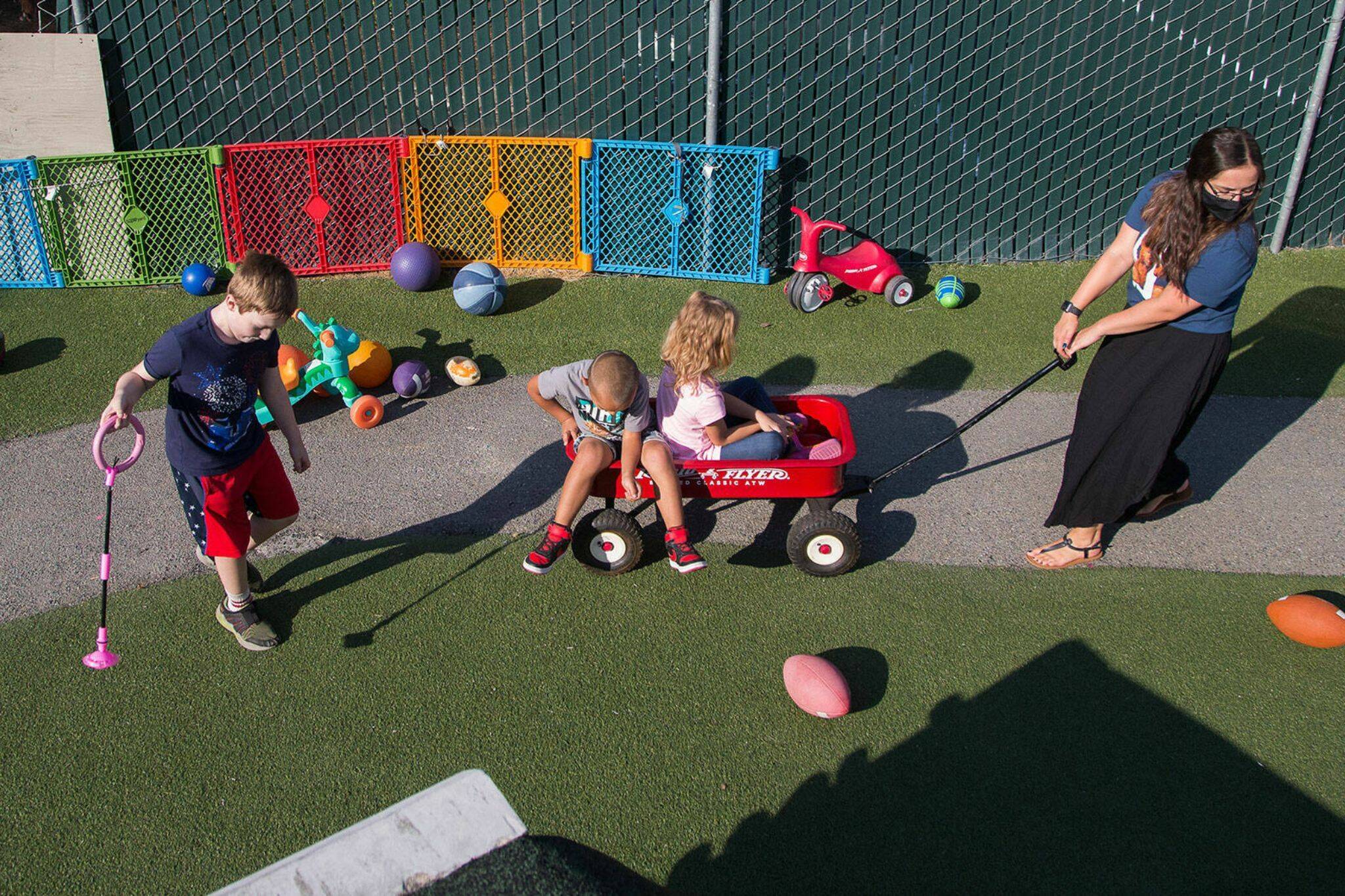 Emilee Swenson pulls kids around in a wagon at HopeWorks’ child care center Tomorrow’s Hope, a job training program for people interested in child care, on Tuesday, Sept. 7, 2021 in Everett, Washington. HopeWorks is one of the organizations reciving funding from the ARPA $4.3 million stipend. (Andy Bronson / The Herald)