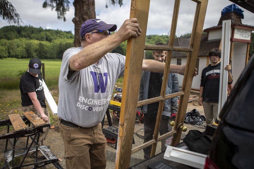 Jeff Forbes moves a door at the Wayside Chapel. His grandson, Michael Durkee, 15, is leading the chapel renovation effort for his Eagle Scout project. Forbes also assisted his son, Robert Forbes, when he did a chapel renovation for his Eagle Scout project in 2007. (Annie Barker / The Herald)

