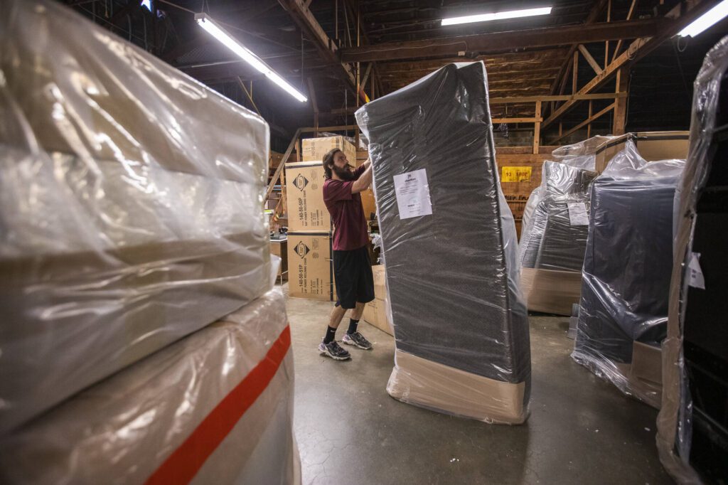 Tanner Mock begins unwrapping new furniture that has been delivered on Thursday, Aug. 24, 2023 in Everett, Washington. (Olivia Vanni / The Herald)
