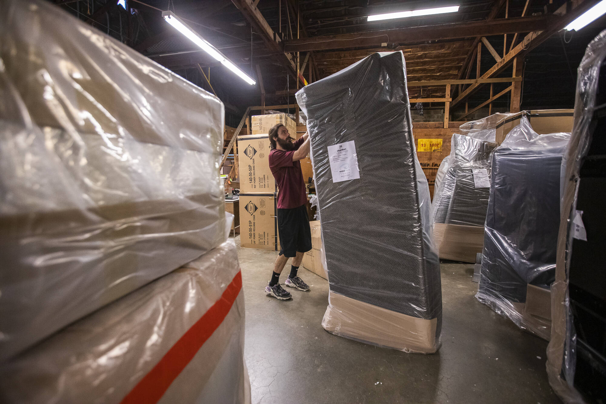 Tanner Mock begins unwrapping new furniture that has been delivered on Thursday, Aug. 24, 2023 in Everett, Washington. (Olivia Vanni / The Herald)