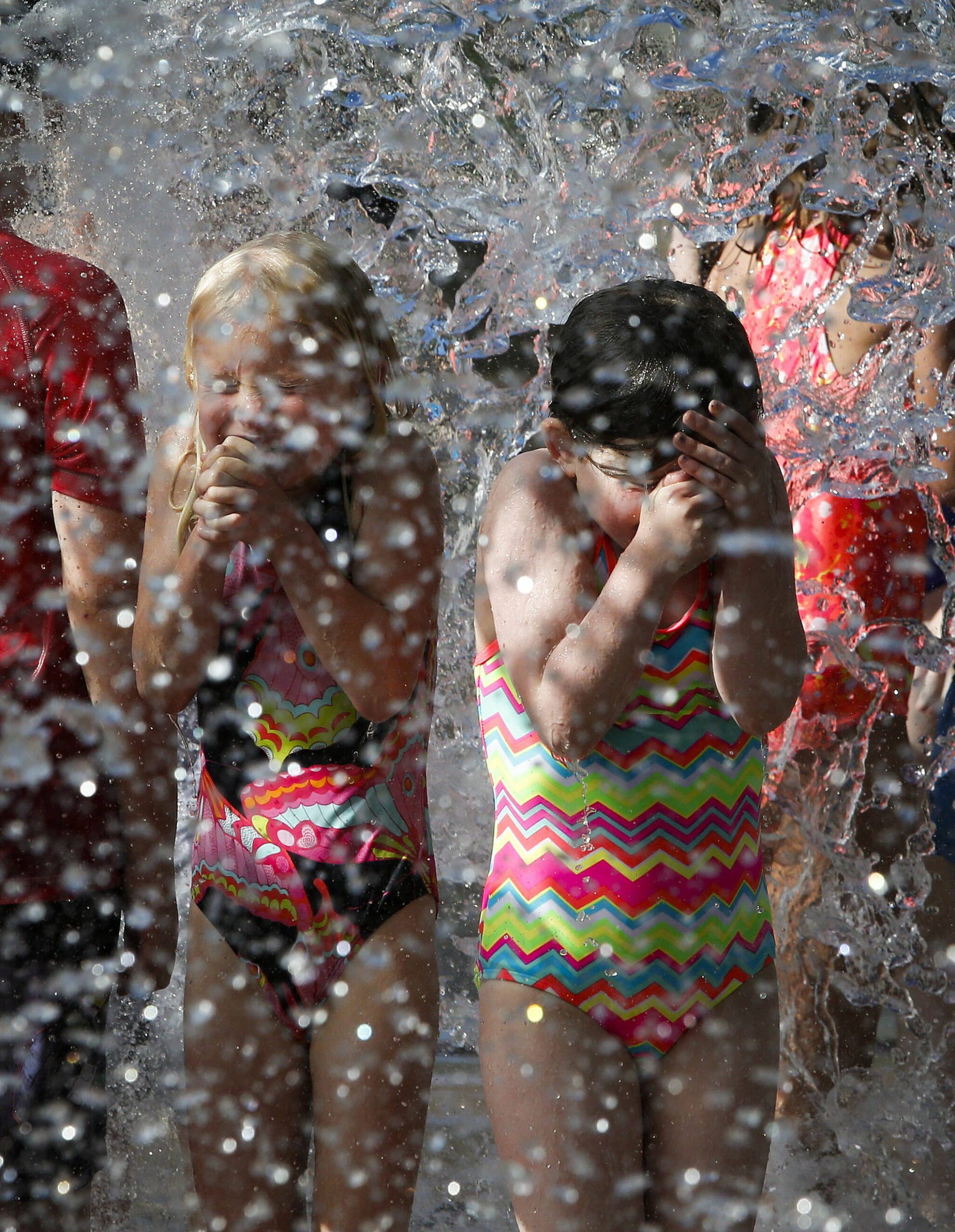 Water splashes down onto kids playing in the Hazel Miller Spray Park at City Park in Edmonds, Washington. (Ian Terry / The Herald file)