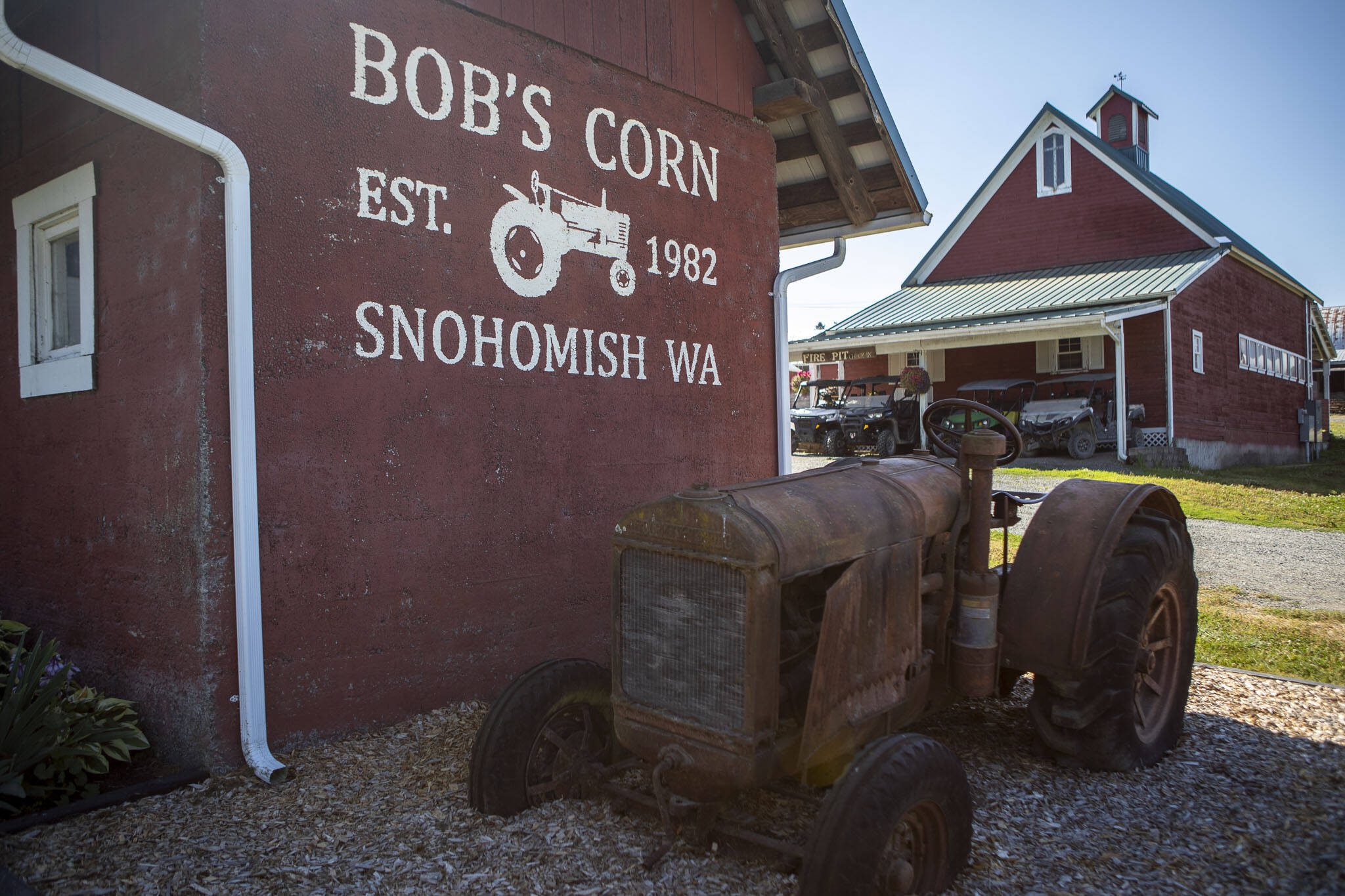 A tractor sits next to barns at Bob’s Corn and Pumpkin Farm in Snohomish, Washington on Thursday, July 27, 2023. (Annie Barker / The Herald)