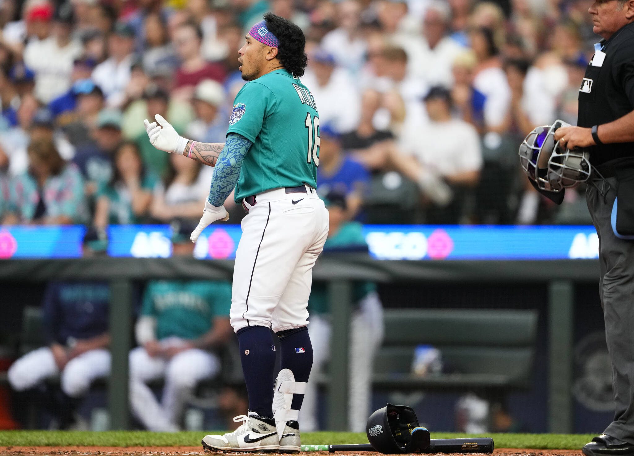 The Mariners’ Kolten Wong removes his batting gear after striking out swinging against the Tigers to end the third inning of a game on July 15 in Seattle. (AP Photo/Lindsey Wasson)