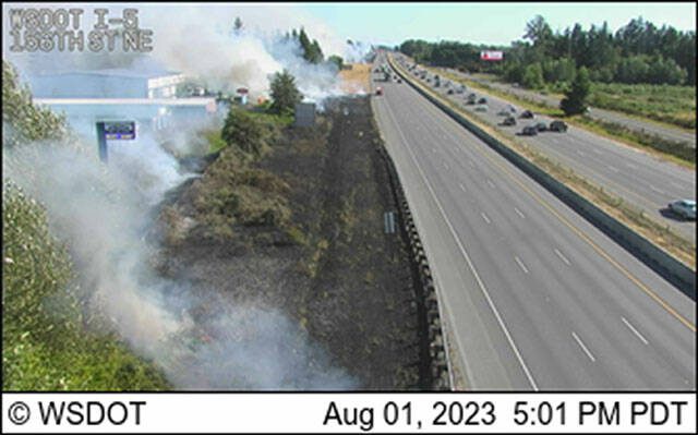 Traffic cameras on Tuesday showed heavy smoke and flames at separate fires in dry grass right along the freeway, near the exits to 144th and 156th streets NE. (Washington State Department of Transportation)