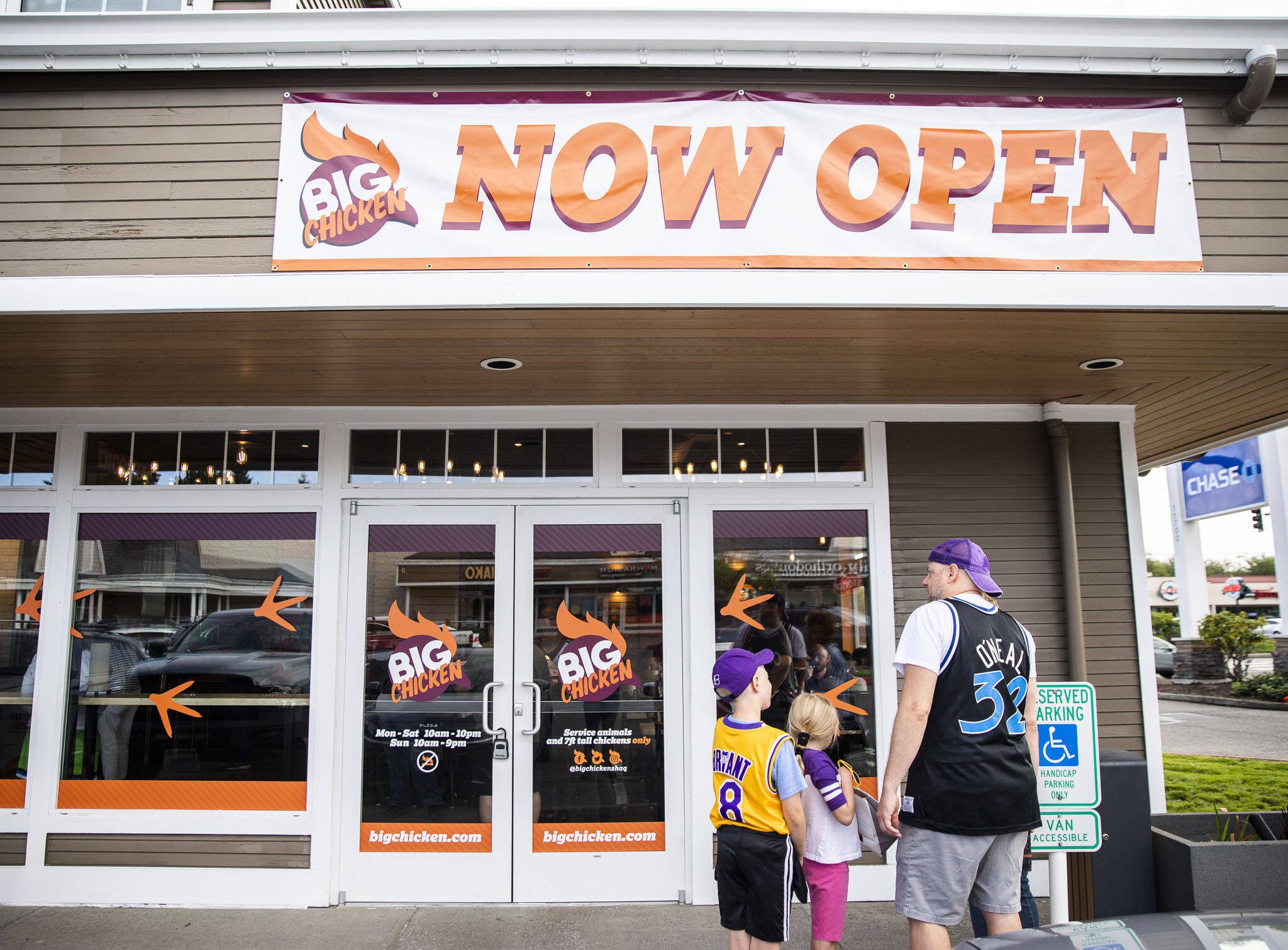 People gather outside of the new Big Chicken during the grand opening on Thursday, Aug. 10, 2023 in Mukilteo, Washington. (Olivia Vanni / The Herald)
