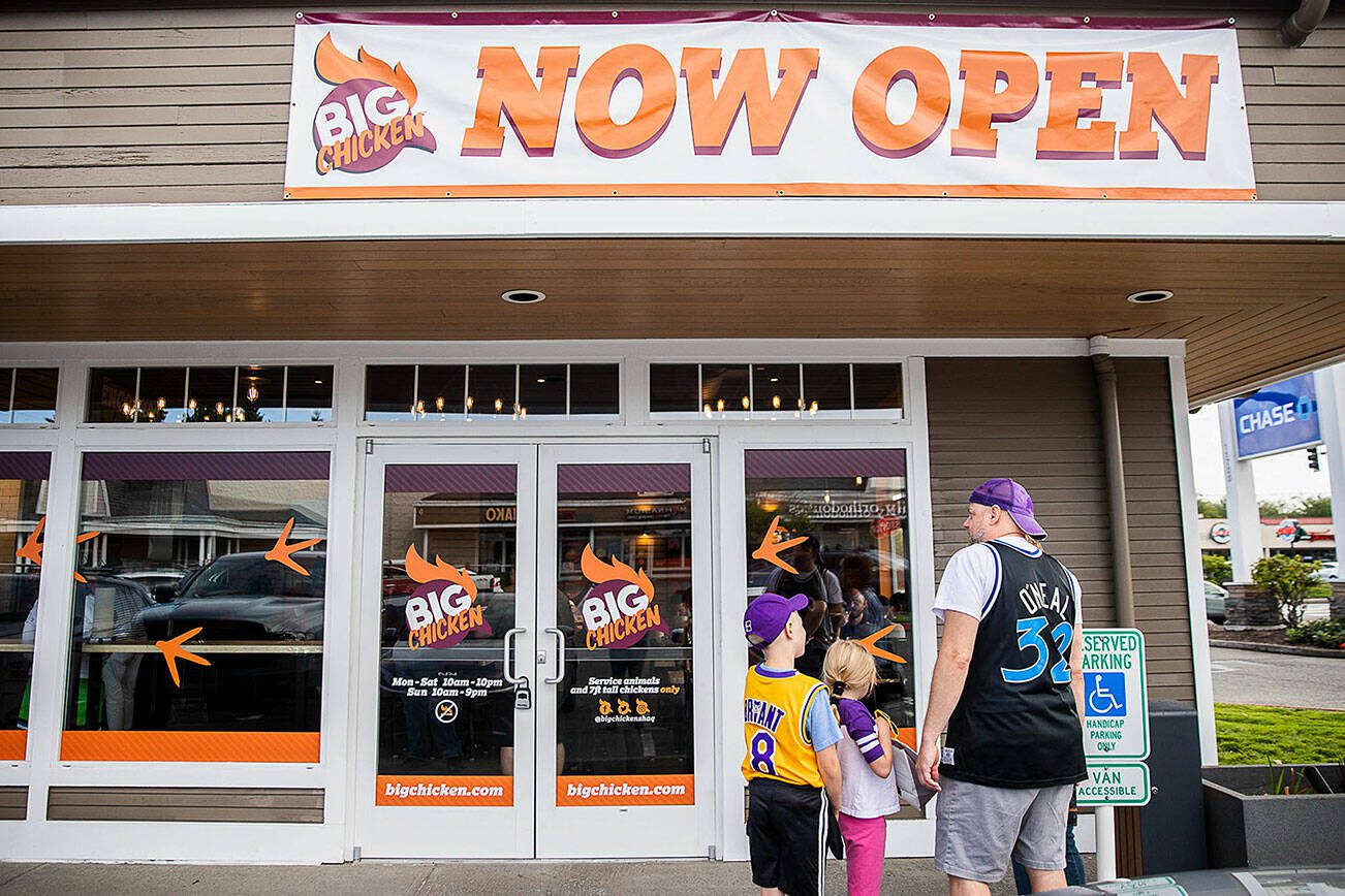 People gather outside of the new Big Chicken during the grand opening on Thursday, Aug. 10, 2023, in Mukilteo, Washington. (Olivia Vanni / The Herald)