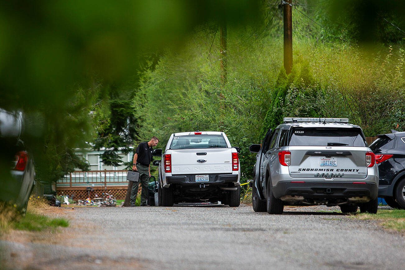 A Snohomish County sheriff's deputy walks toward the scene of shooting that left one dead on Thursday, Aug. 10, 2023, in Lynnwood, Washington. (Olivia Vanni / The Herald)