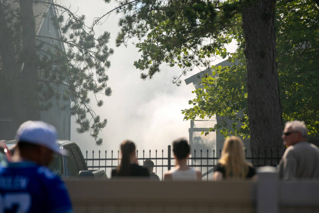 Residents from an adjacent complex watch smoke fill the air during an apartment fire at the Park 120 apartment complex on Casino Road on Friday, August 11, 2023, in Everett, Washington. (Ryan Berry / The Herald)

