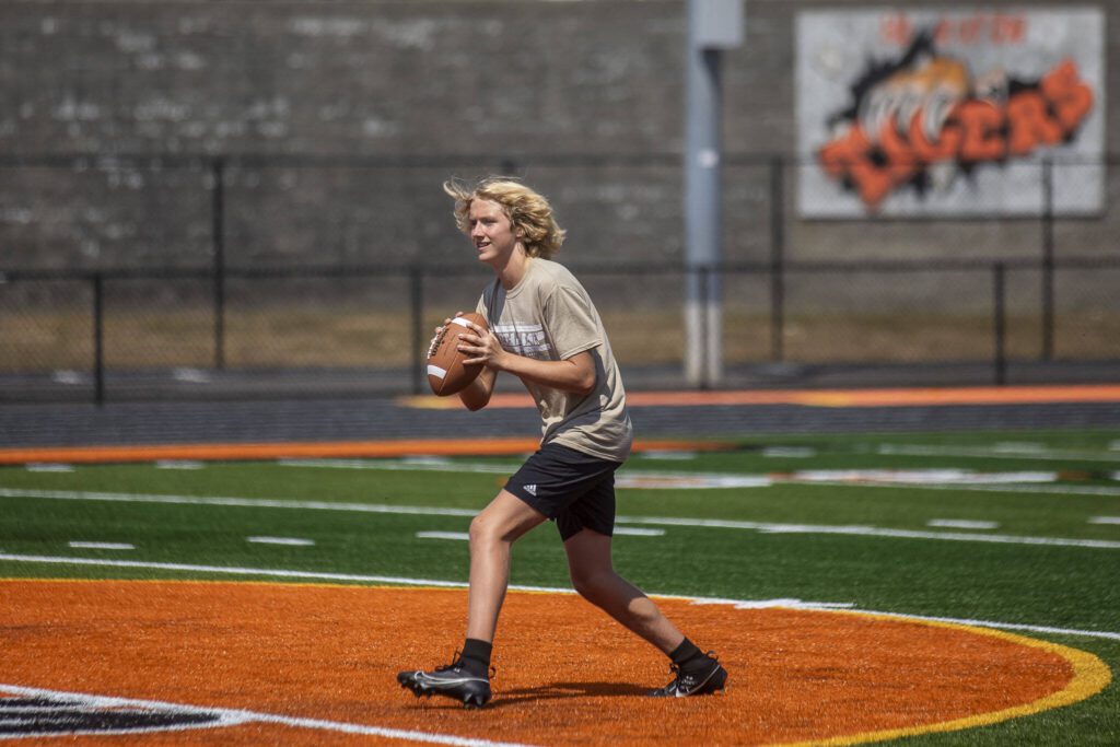 Members of the Granite Falls football team run drills during a soft opening for the new track and field Monday at Granite Falls High School. (Annie Barker / The Herald)
