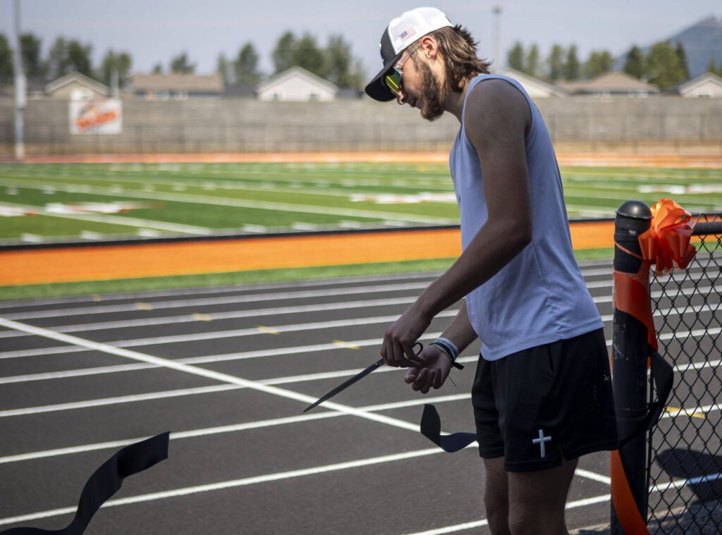Granite Falls senior Kaden LaPlaunt, 17, cuts a ribbon during a soft opening for the new track and field Monday at Granite Falls High School. (Annie Barker / The Herald)
