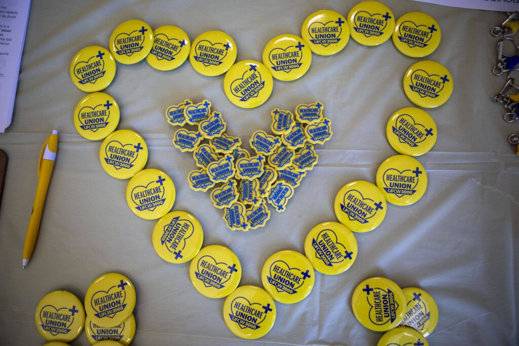 Buttons and pens are displayed during a Town Hall with UFCW 3000 Nurses at Providence Regional Medical Center at the Everett Labor Temple in Everett, Washington on Wednesday, Aug. 16, 2023. (Annie Barker / The Herald)
