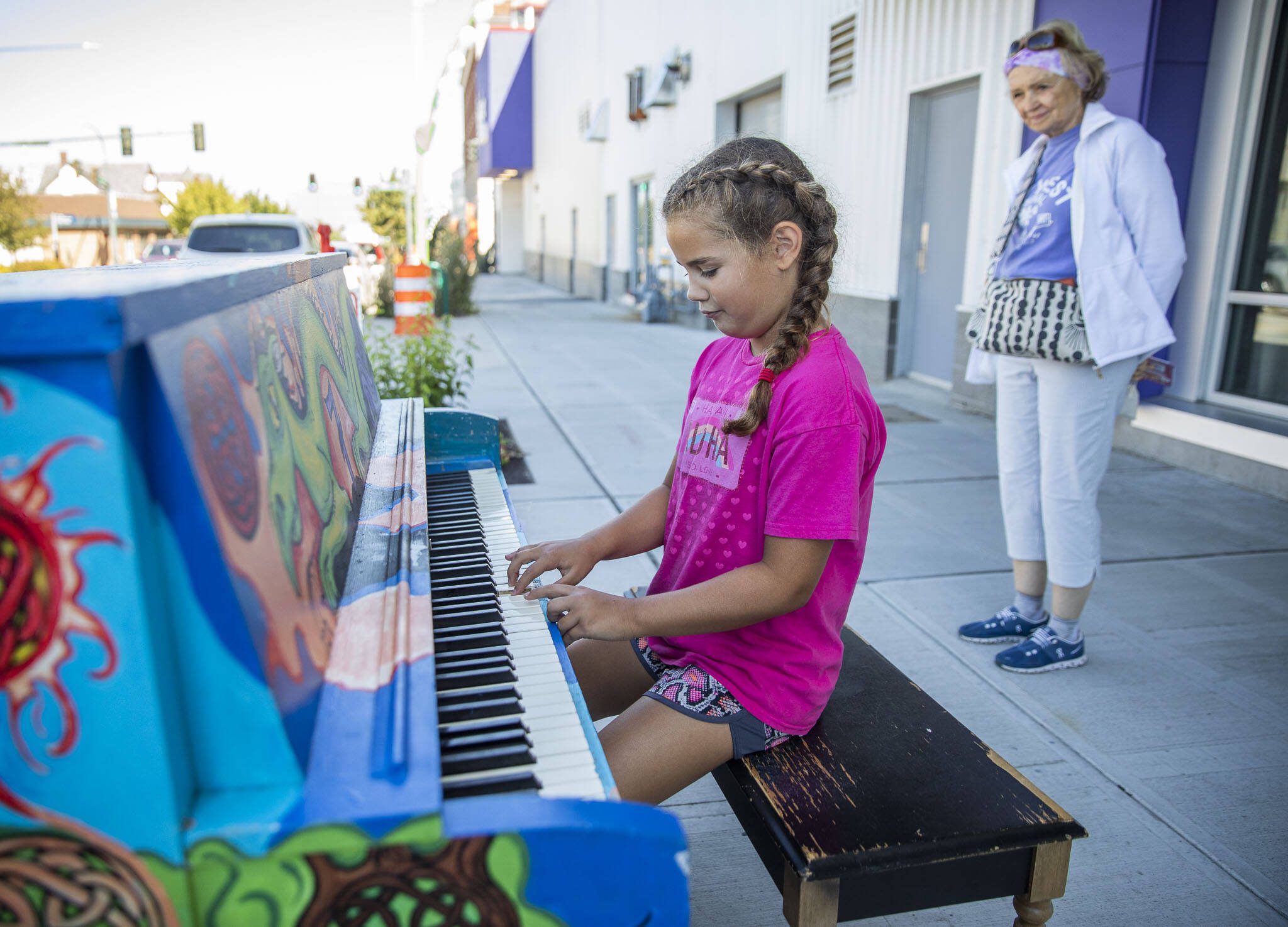 Kenzie Norton, 10, plays a part of the song Baby Bumblebee on piano painted by Amber Forrest in front of the Imagine Children’s Museum on Wednesday, Aug. 16, 2023 in Everett, Washington. (Olivia Vanni / The Herald)