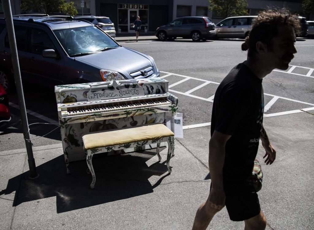 A man walks by the “Produce Sounds” piano by Elizabeth Person on display in front of the Sno-Isle Food Co-op on Wednesday, Aug. 16, 2023 in Everett, Washington. (Olivia Vanni / The Herald)
