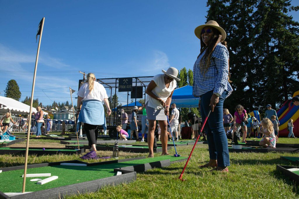 Festival patrons play mini golf for free during Taste Edmonds on Saturday, August 12, 2023, at Frances Anderson Play Field in Edmonds, Washington. (Ryan Berry / The Herald)
