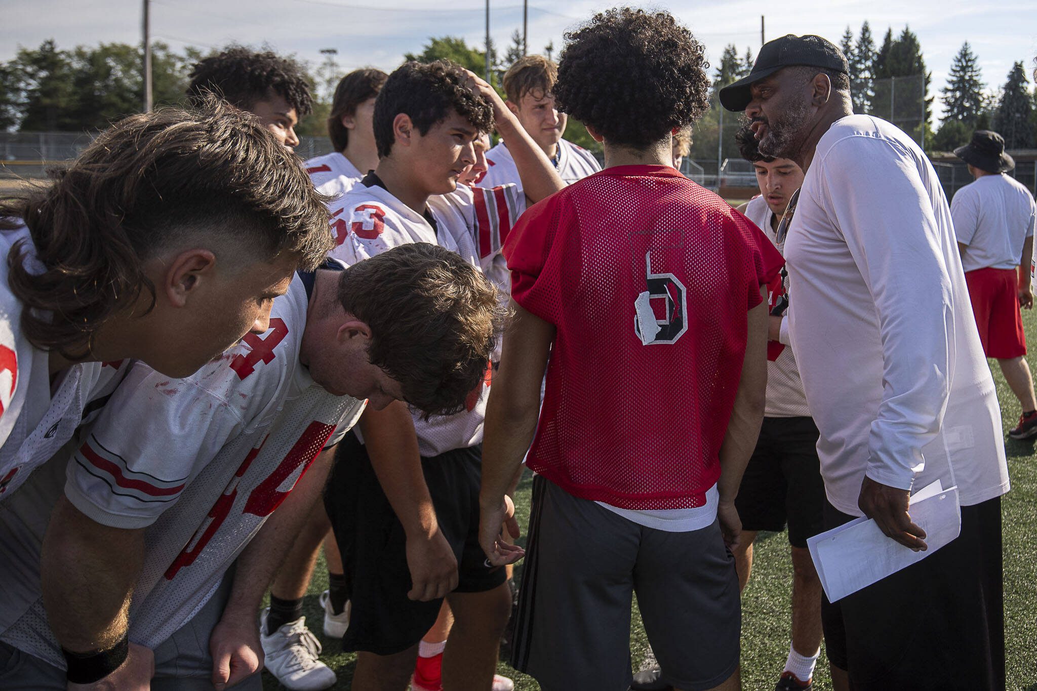 Head Coach Archie Malloy, right, gives directions in a huddle during a football practice Thursday at Mountlake Terrace High School. (Annie Barker / The Herald)