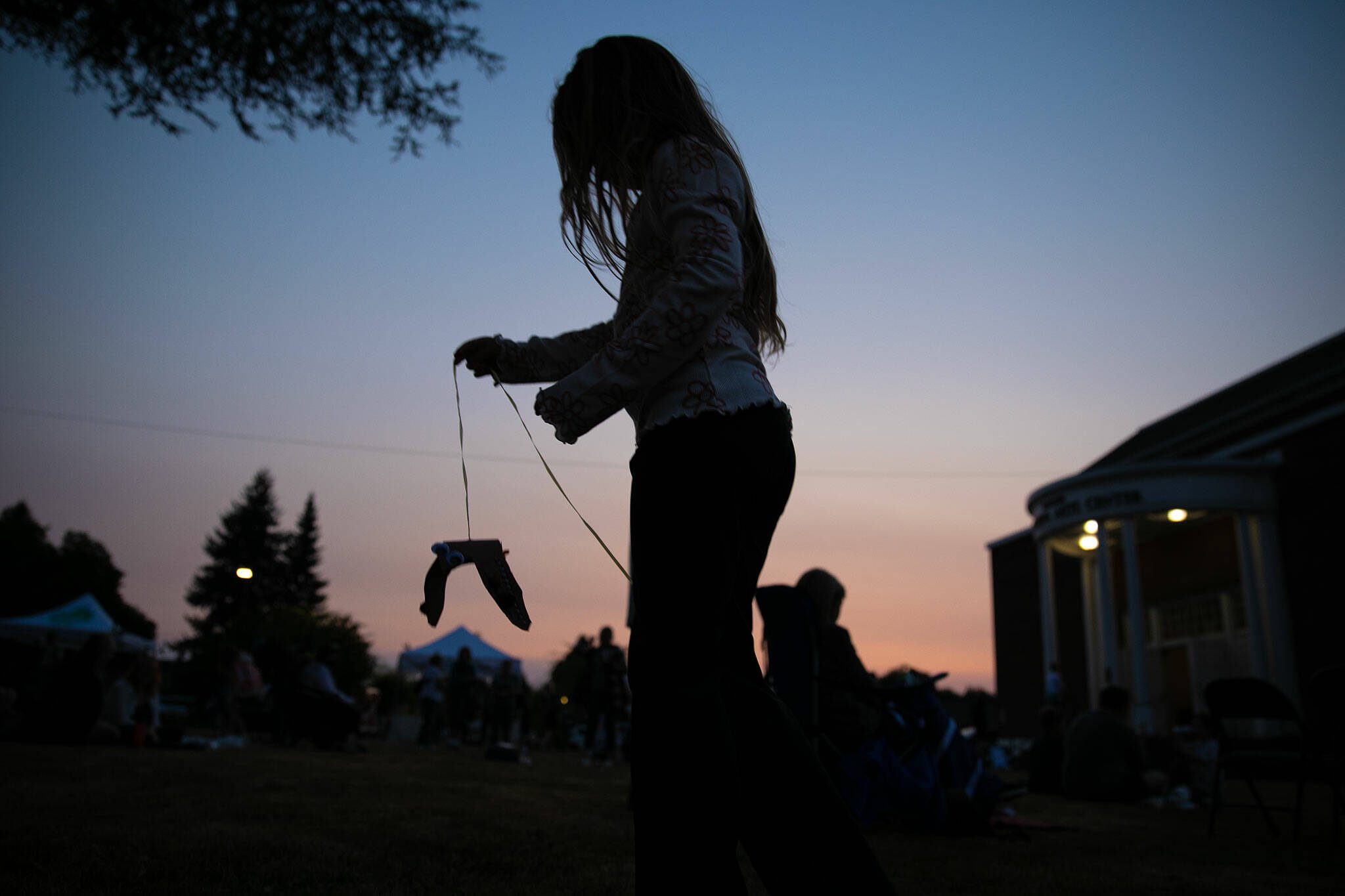 A young girl weaves through the crowd with a paper swift during the Pilchuck Audubon Society’s Swift Night Out on Saturday, August 19, 2023, at Frank Wagner Elementary School in Monroe, Washington. (Ryan Berry / The Herald)