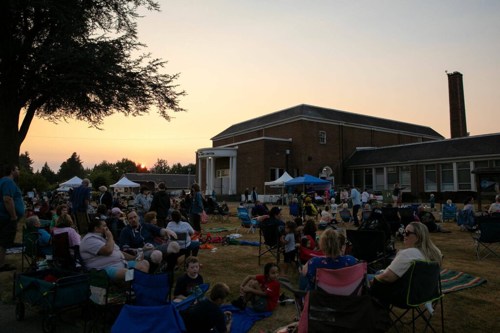 The sun sets as people hope to see Vaux’s swifts during the Pilchuck Audubon Society’s Swift Night Out on Saturday, August 19, 2023, at Frank Wagner Elementary School in Monroe, Washington. (Ryan Berry / The Herald)
