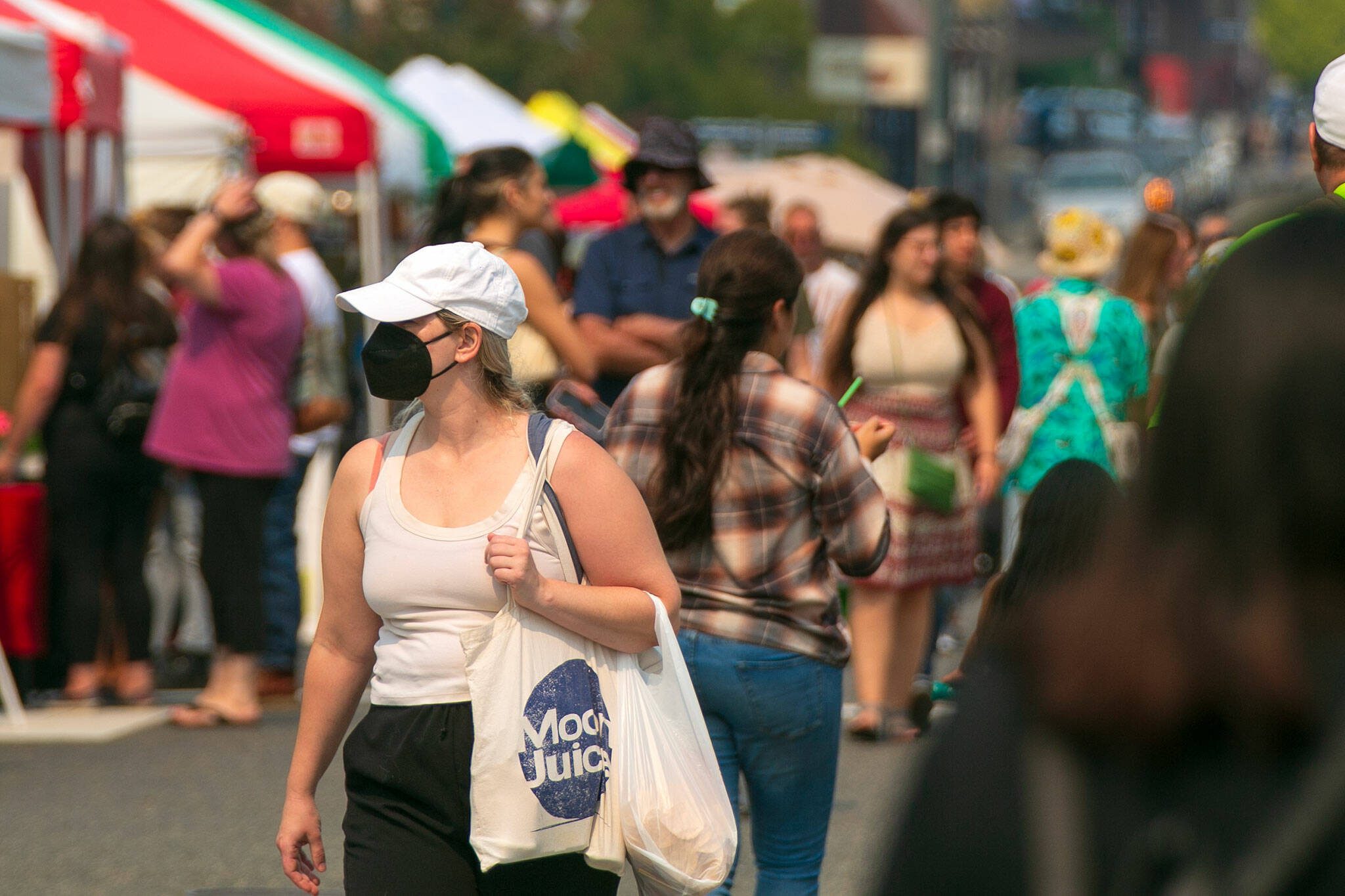 Some visitors at the Everett Farmers Market chose to wear masks as the AQI reached unhealthy levels Sunday, August 20, 2023, in Everett, Washington. (Ryan Berry / The Herald)