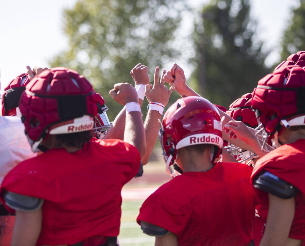 Stanwood players huddle before taking a water break during practice on Friday, Aug. 18, 2023 in Stanwood, Washington. (Olivia Vanni / The Herald)
