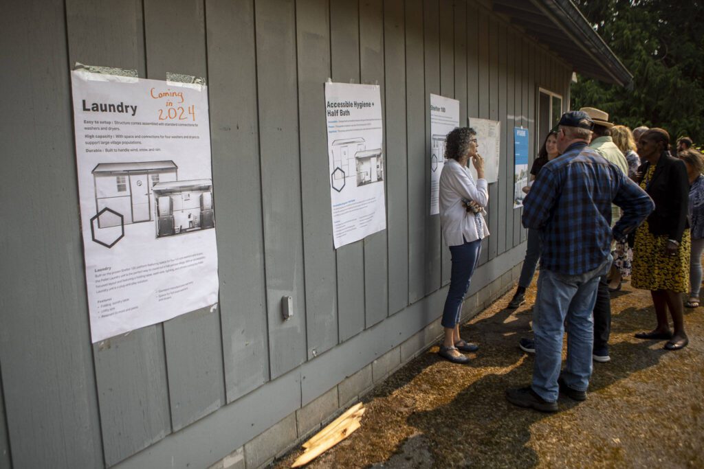 Information about future housing plans is displayed during a groundbreaking ceremony for Faith Family Village at Faith Lutheran Church in Everett, Washington on Monday, Aug. 21, 2023. (Annie Barker / The Herald)
