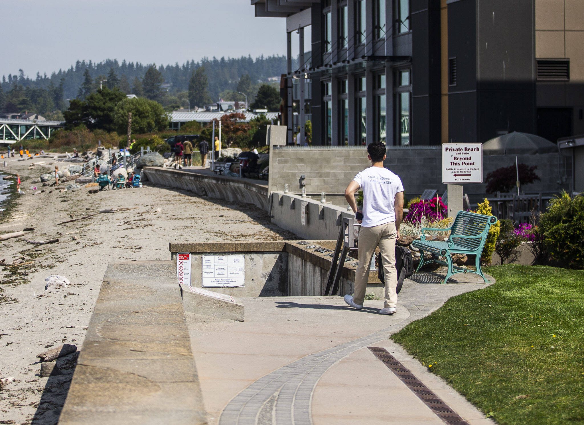 A man pauses to read a sign alerting beach users to the private section of the beach along the Edmonds waterfront on Friday, Aug. 25, 2023 in Edmonds, Washington. (Olivia Vanni / The Herald)