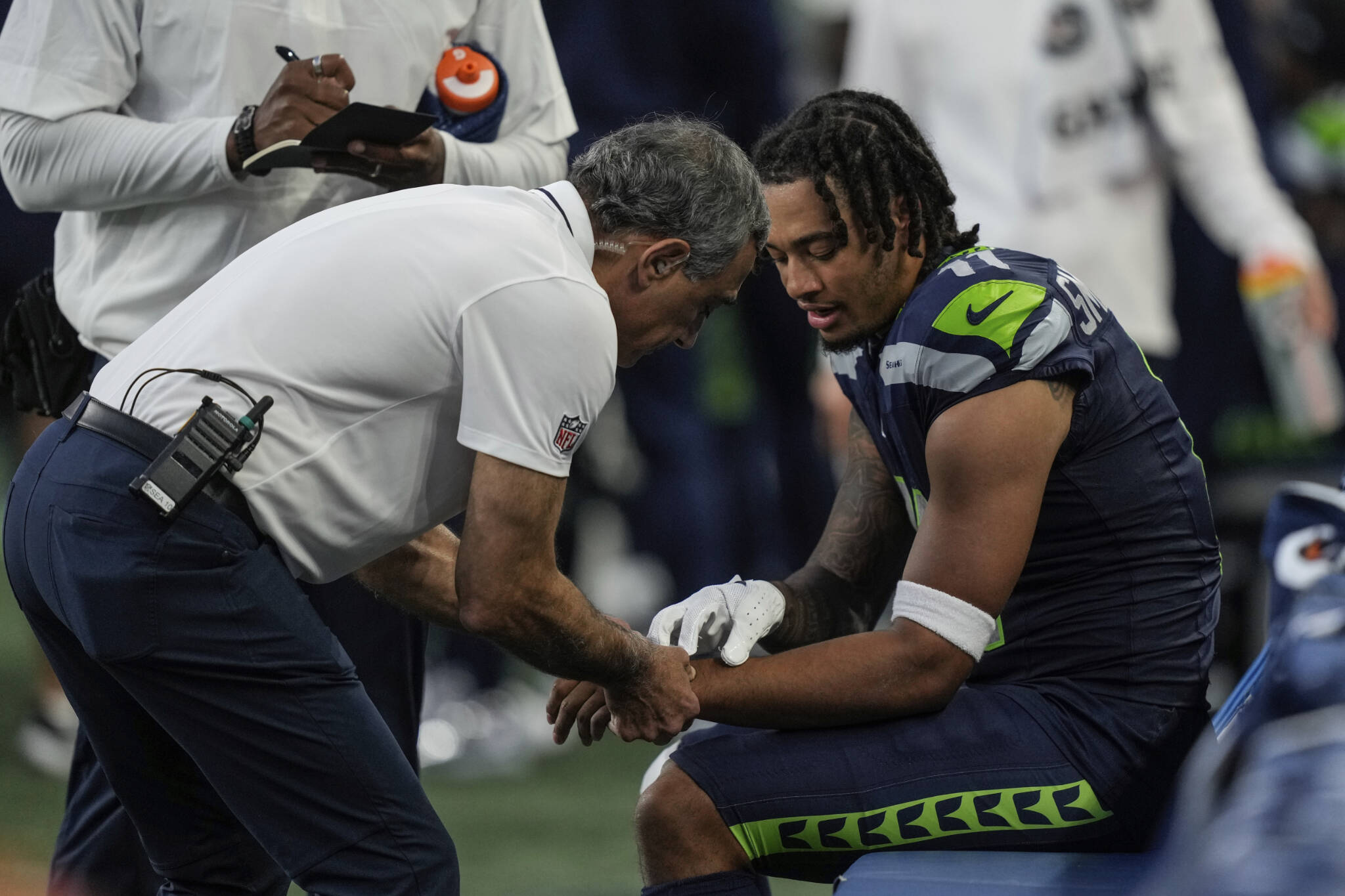 Seattle Seahawks team personnel check out the wrist of wide receiver Jaxon Smith-Njigba during an NFL preseason football game against the Dallas Cowboys, Saturday, Aug. 19, 2023, in Seattle. The Seahawks won 22-14. (AP Photo/Stephen Brashear)