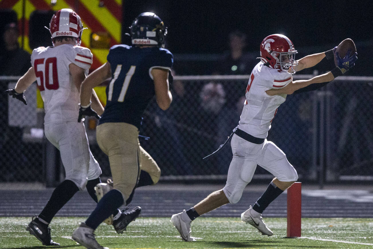 Stanwood’s Canyon Bumgarner reaches the ball in to the end zone looking for a touchdown during the Stilly Cup against Arlington on Friday, Sept. 30, 2022 in Arlington, Washington. (Olivia Vanni / The Herald)