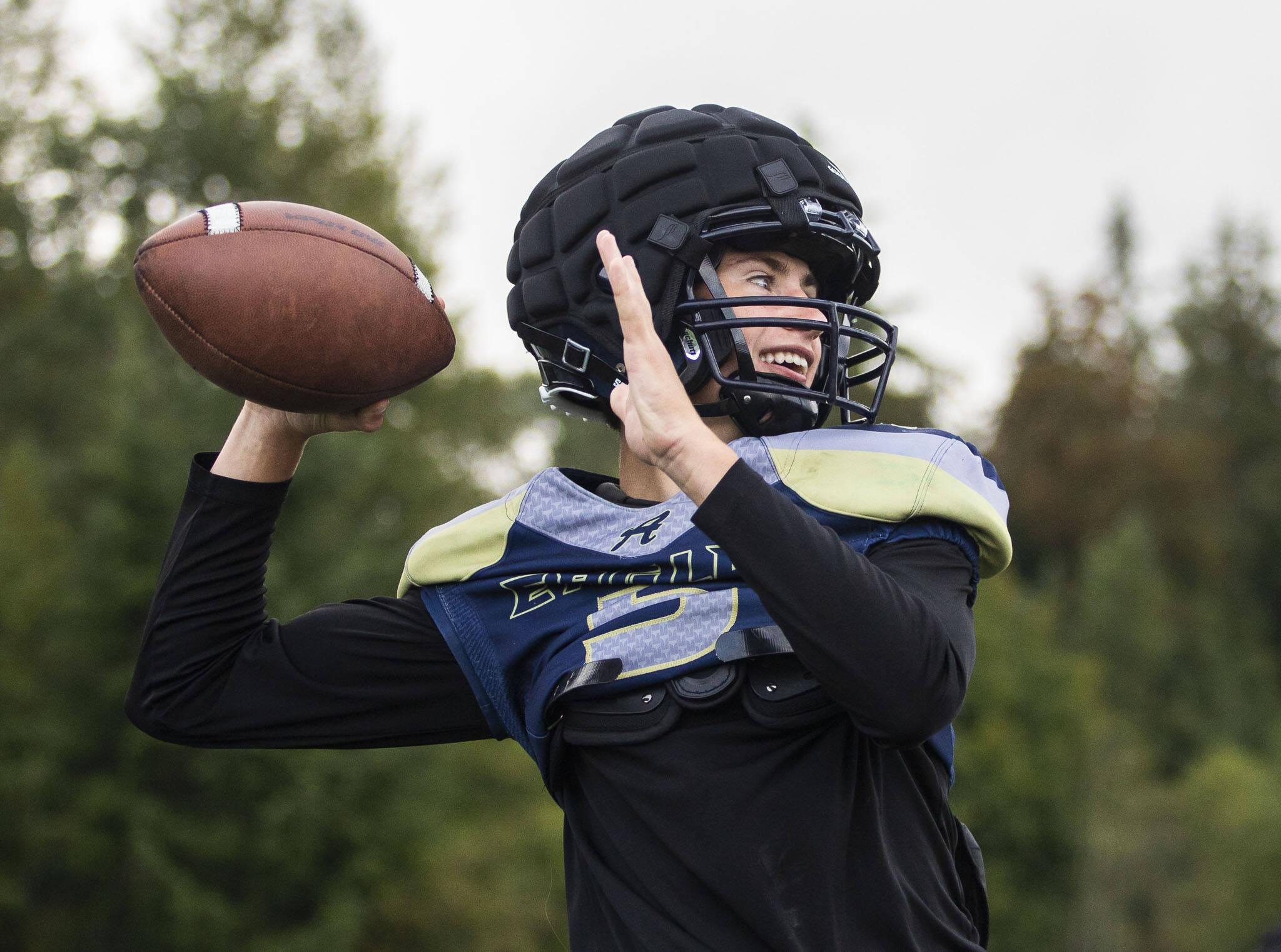 Jacoby Falor smiles while throwing the ball during practice on Wednesday at Arlington High School. (Olivia Vanni / The Herald)