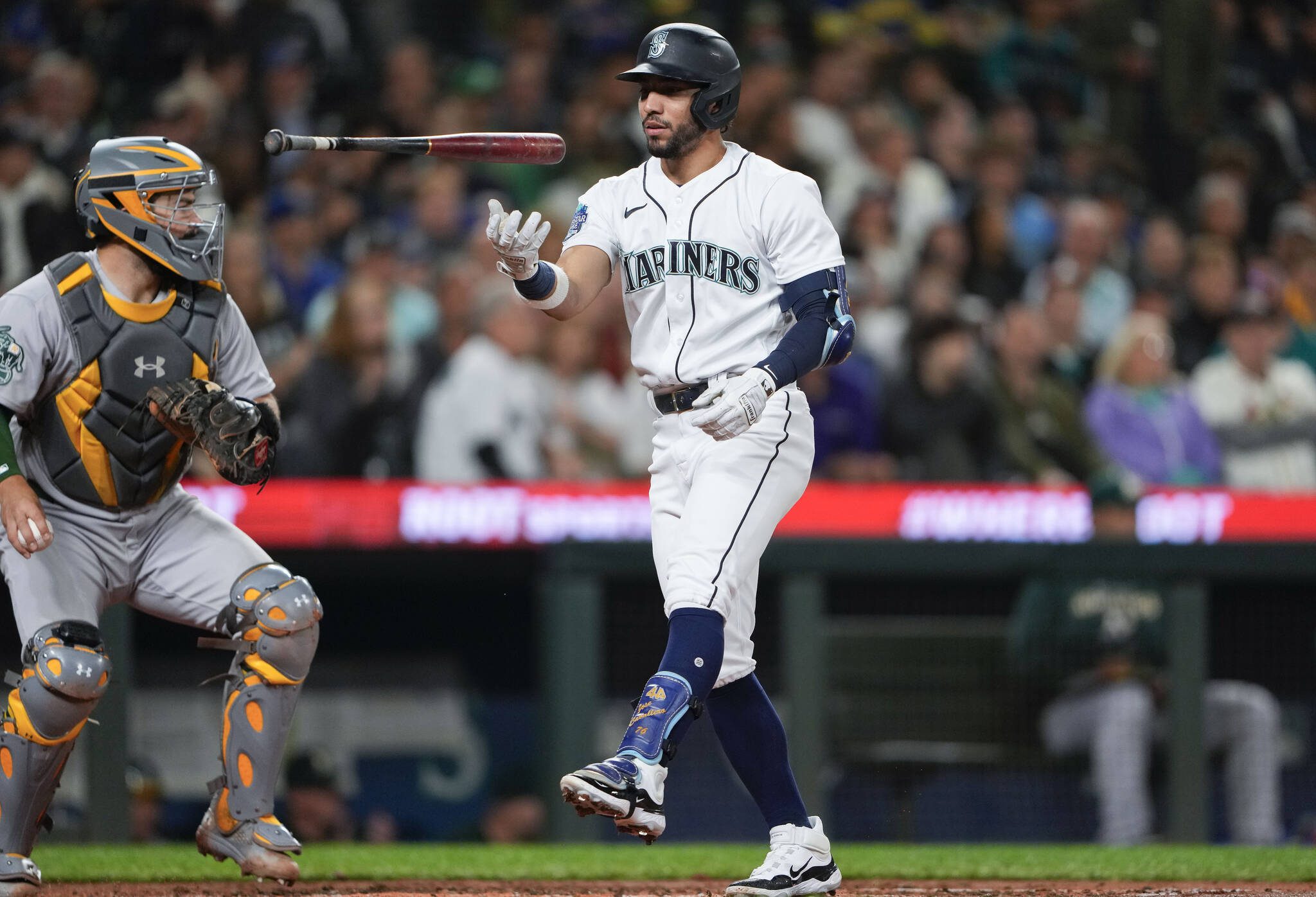 The Mariners’ Jose Caballero tosses his bat in the air after striking out as Athletics catcher Shea Langeliers looks on during the third inning of a game Tuesday in Seattle. (AP Photo/Lindsey Wasson)