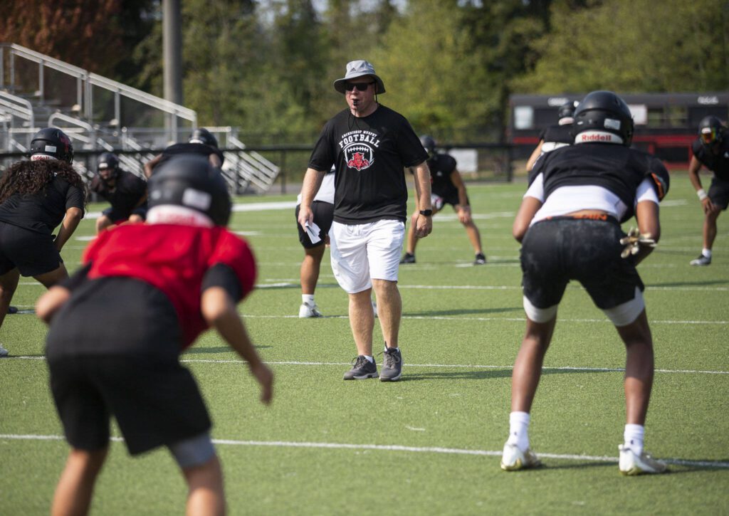 Archbishop Murphy head coach runs the team through warm ups during practice on Thursday, Aug. 24, 2023 in Everett, Washington. (Olivia Vanni / The Herald)

