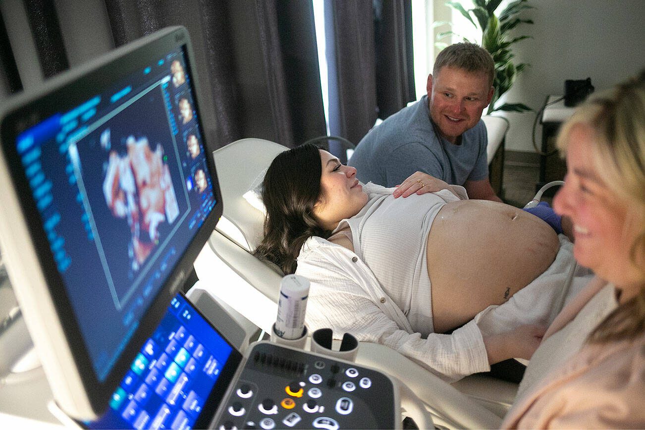 Spouses Franchesca and Don Simpson talk about their baby girl’s “chubby cheeks” and “button nose” as Kelly Fox RDMS RVT performs a live-view 3D ultrasound on the expecting mother Saturday, August 26, 2023, at Wonder Baby Ultrasound Studio in Everett, Washington. The Simpsons are expecting their first child in October. (Ryan Berry / The Herald)