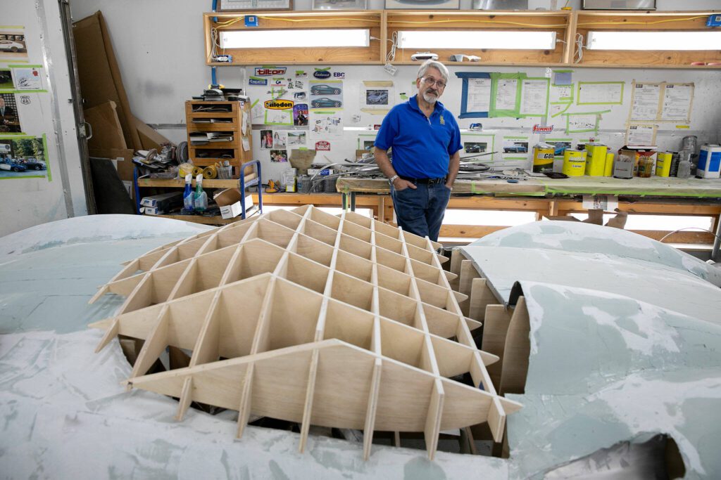 Jim Simpson, who grew up an avid fan of the 1967 anime “Speed Racer” stands in his shop next to his in-progress adaptation of the show’s Mach Five on Friday, August 25, 2023, in Clinton, Washington. (Ryan Berry / The Herald)
