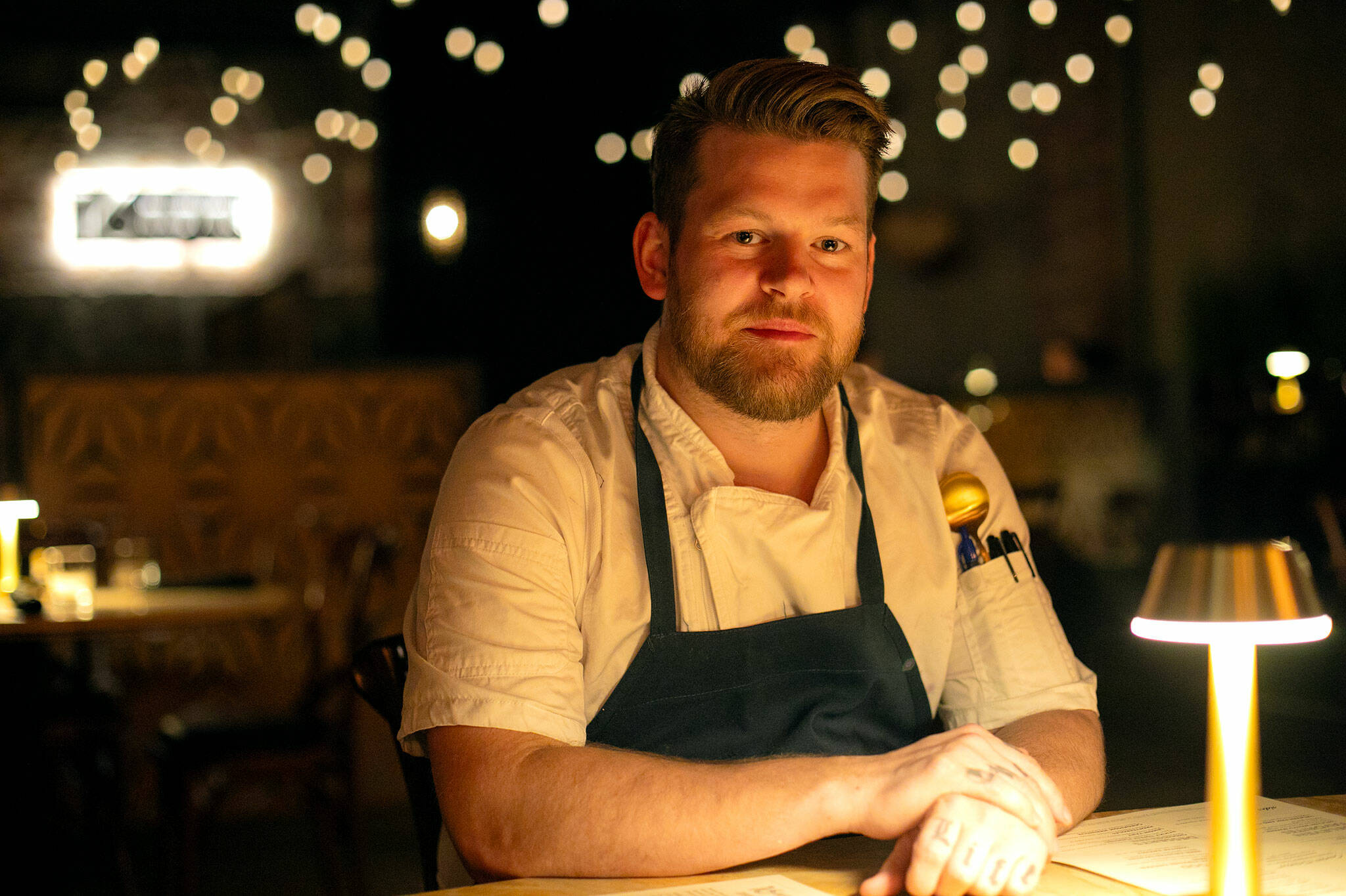 16Eleven head chef Joel Childs sits in the dining room of his new restaurant on Wednesday, August 23, 2023, in Everett, Washington. The restaurant features steak, seafood and shared plates and is housed on the ground floor of APEX Art and Culture Center downtown. (Ryan Berry / The Herald)
