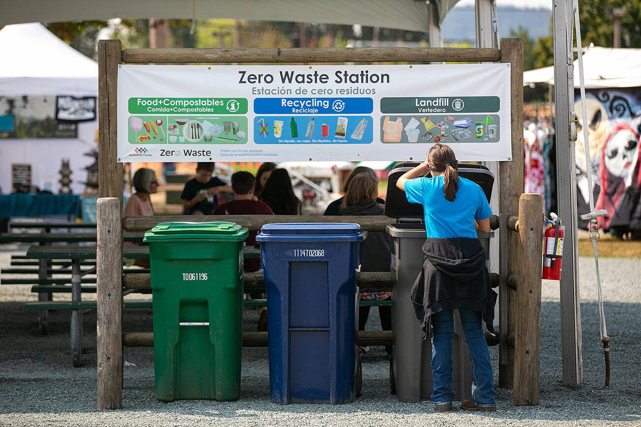 A fair-goer drops off some trash at one of the Evergreen State Fair’s many zero-waste stations during opening day Thursday, August 24, 2023, in Monroe, Washington. (Ryan Berry / The Herald)