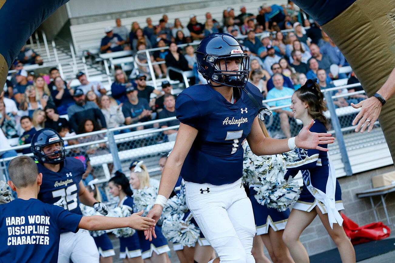 Arlington starting quarterback Leyton Martin runs onto the field during introductions before the season opener against Kamiak on Friday, Sep. 1, 2023, at Arlington High School in Arlington, Washington. (Ryan Berry / The Herald)