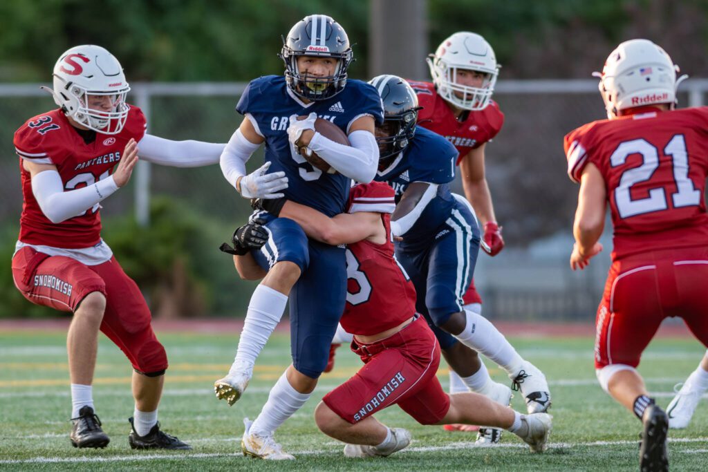 Glacier Peak’s Isaiah Cuellar (9) tries to break through the tackle of Snohomish’s Andrew Seamons (23) during a game on Sept. 1, 2023, at Snohomish High School. (John Gardner / Pro Action Image)

