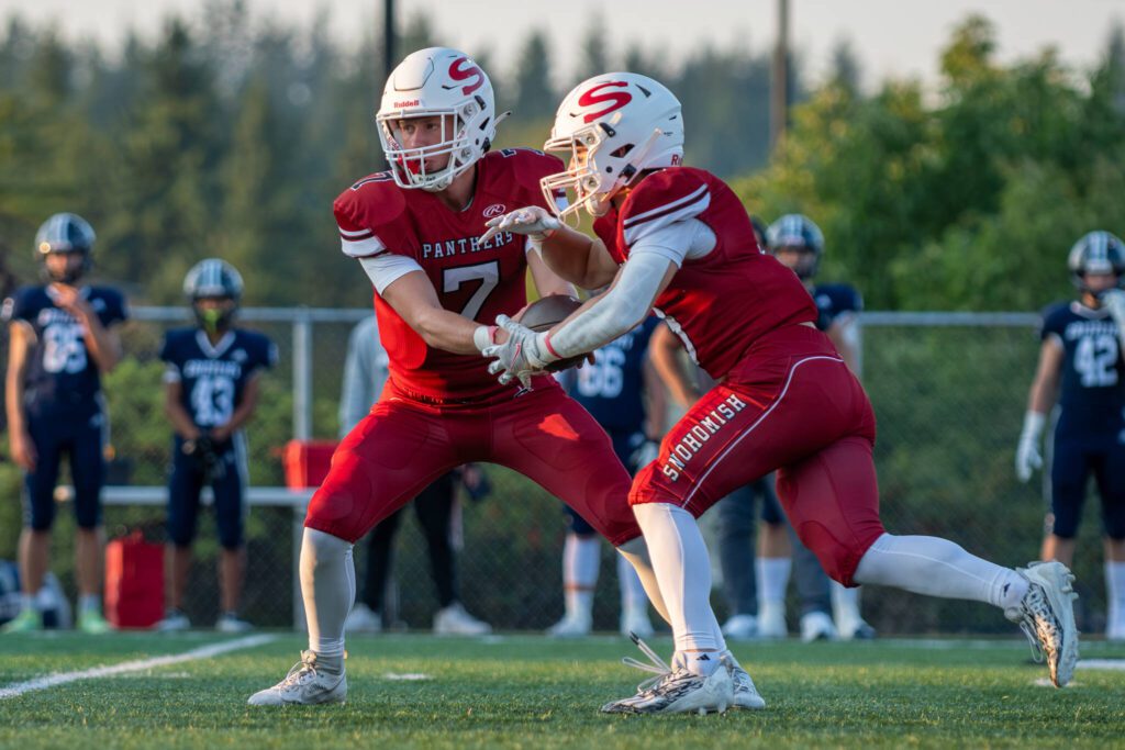 Snohomish quarterback David Hammer (7) hands the ball to running back Brody Strandt (9) during a game against Glacier Peak on Sept. 1, 2023, at Snohomish High School. (John Gardner / Pro Action Image)
