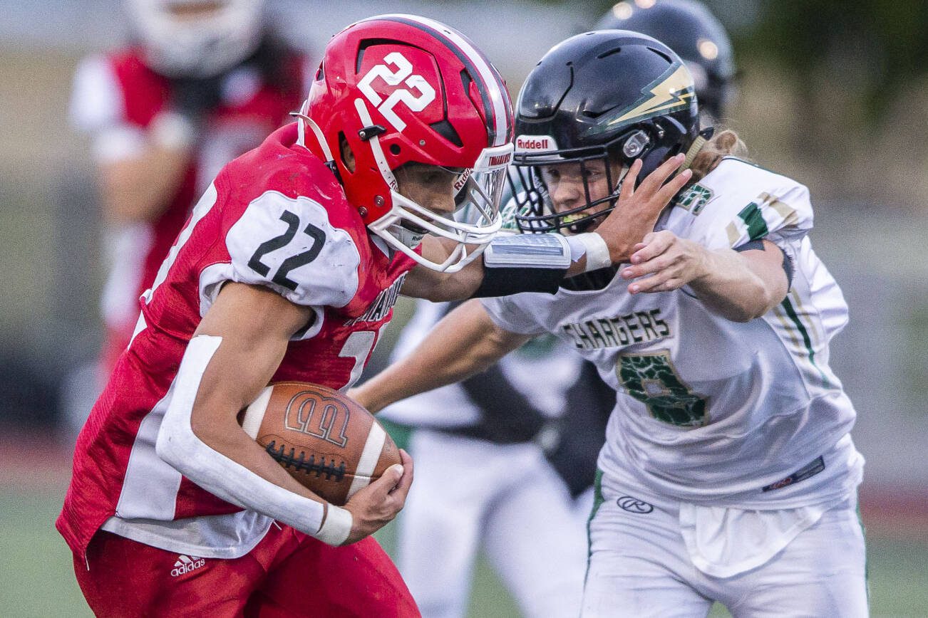 Marysville Pilchuck’s Joseph Davis sticks out his arm to block a tackle by Marysville Getchell's Sean Ewald during the game on Friday, Sept. 16, 2022 in Marysville, Washington. (Olivia Vanni / The Herald)